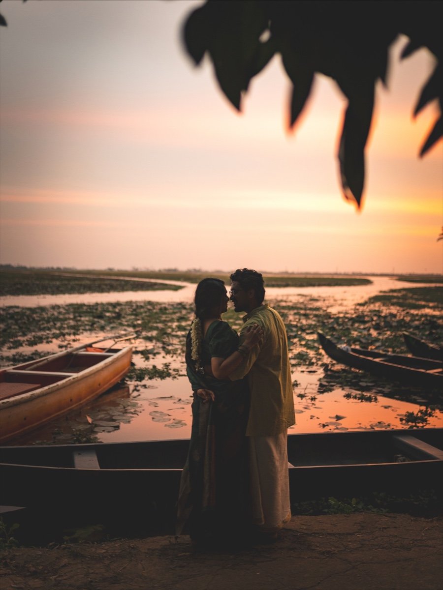 Couple embracing by the Kerala backwaters at golden sunset by Jino and Midhu